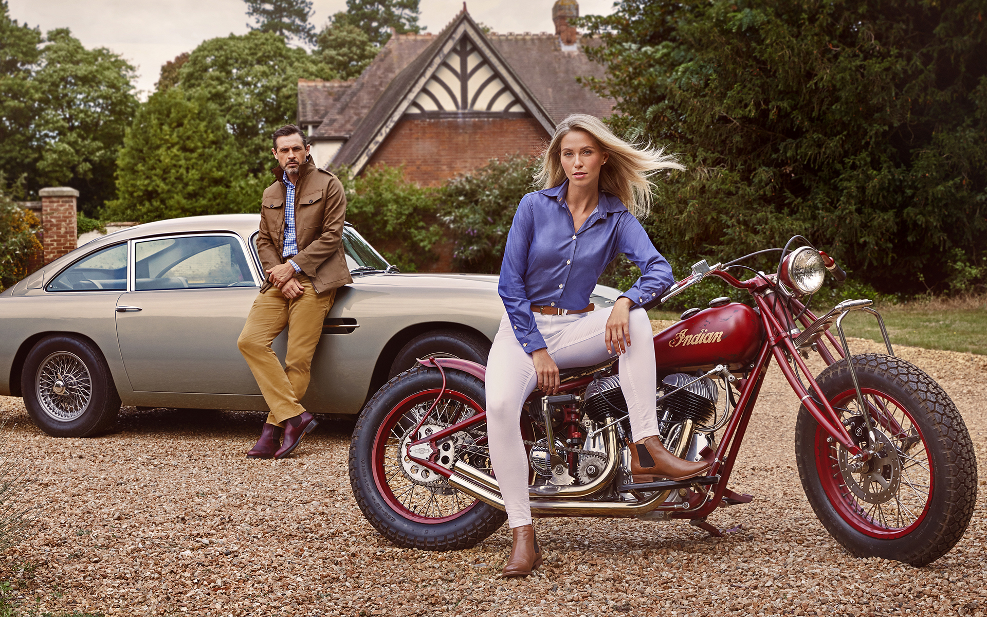 advertising fashion photo shoot for Paul brown clothing male and female model sitting in Aston Martin classic car at egerton house newmarket suffolk